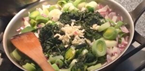Simmering stock and vegetables for stinging nettle soup.